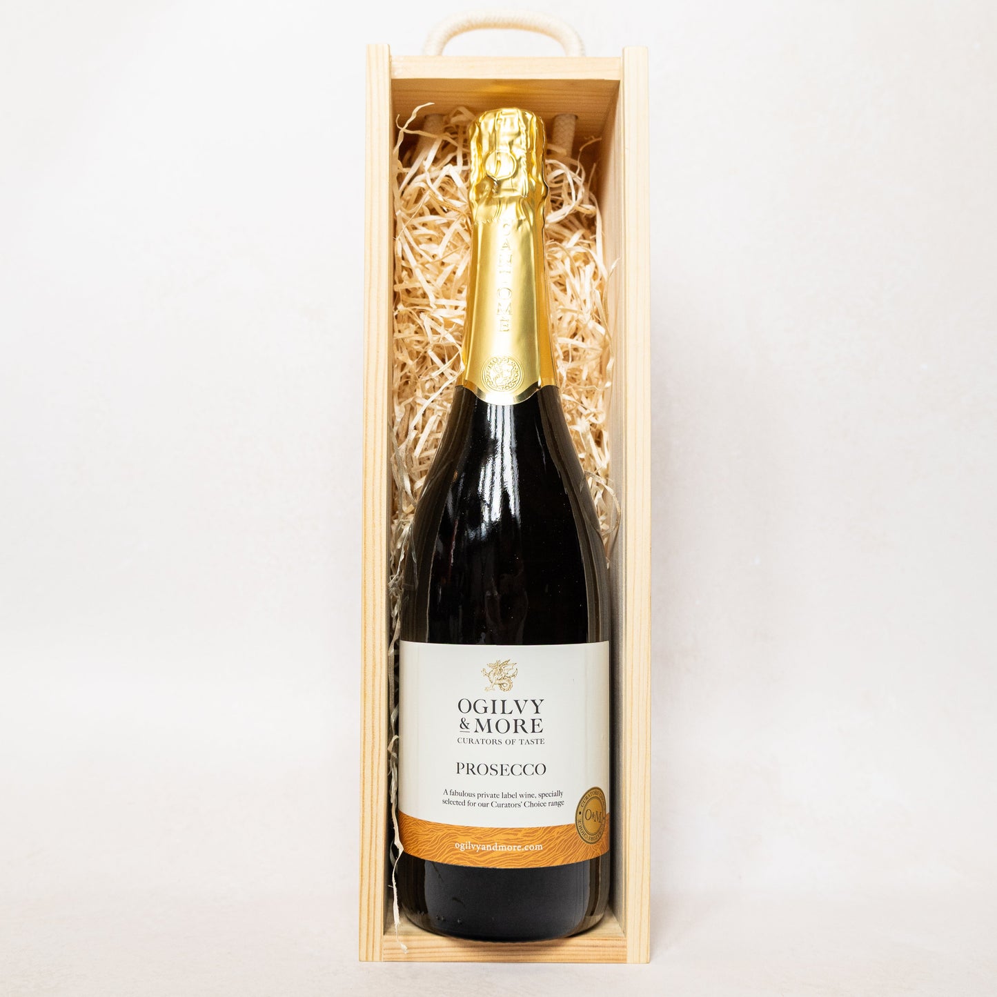 A bottle of Ogilvy & More Prosecco in a wooden gift box on a white background