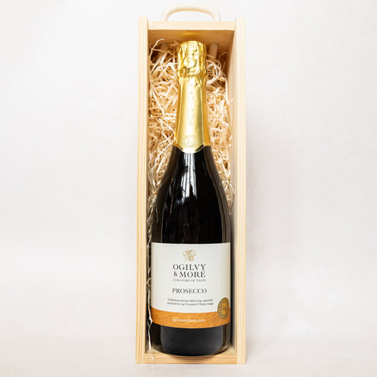 A bottle of Ogilvy & More Prosecco in a wooden gift box on a white background