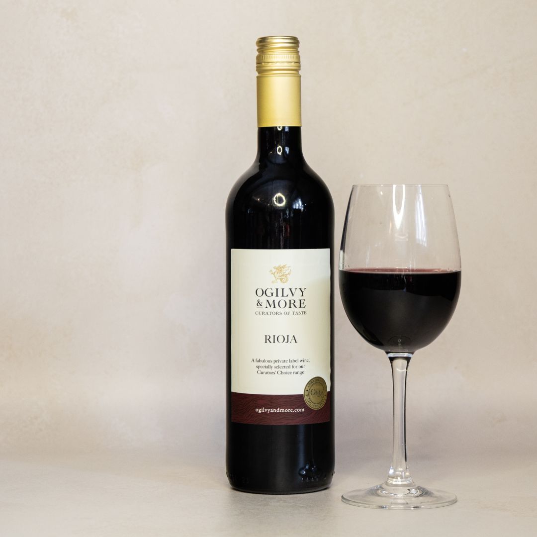 Bottle of Ogilvy & More Rioja wine with a glass of red wine