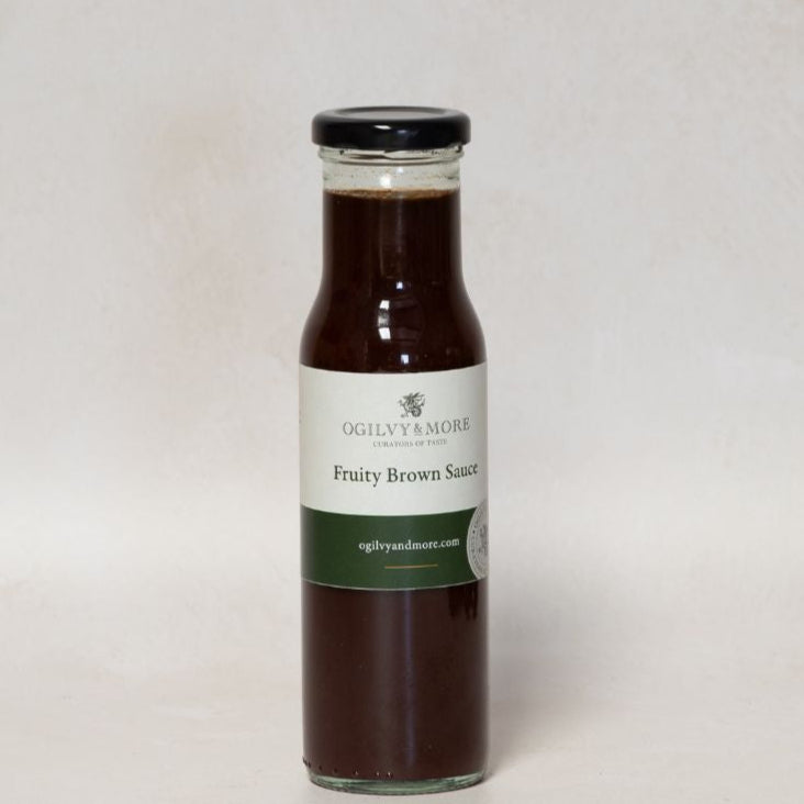 Bottle of Ogilvy & More fruity brown sauce with a label on a light gray background