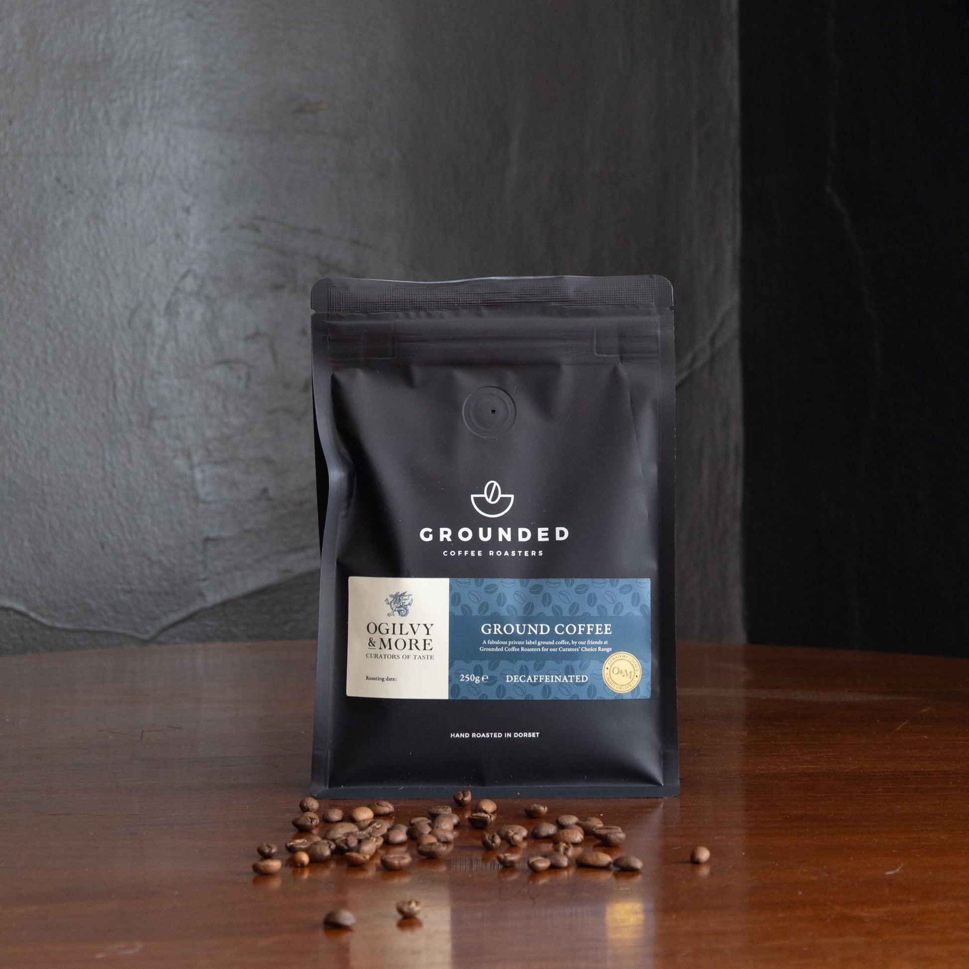 Grounded decaf coffee package with coffee beans on a wooden surface