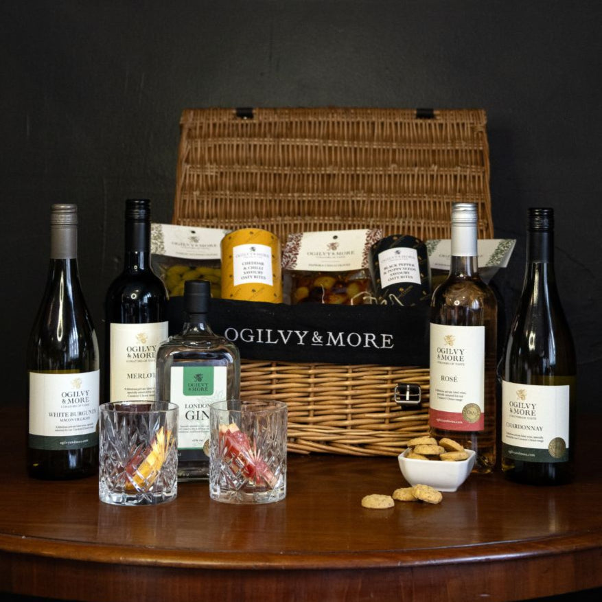 O&M Wine bottles and a basket on a wooden table with a dark background
