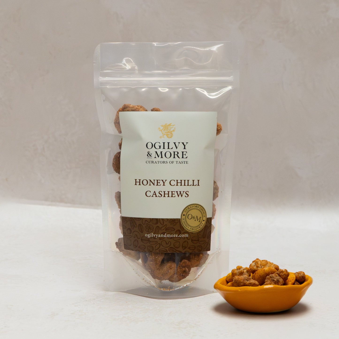 Ogilvy & More honey chilli cashews with a small bowl of cashews on a light background