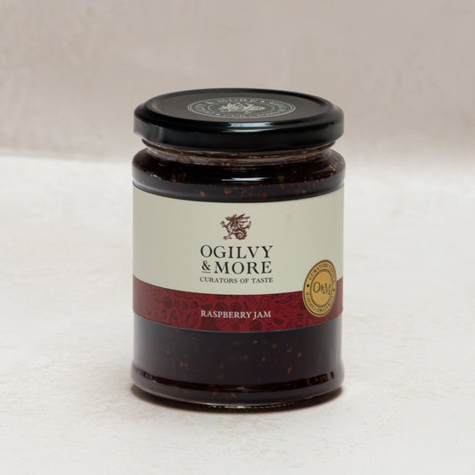 Jar of Ogilvy & More raspberry jam on a white background