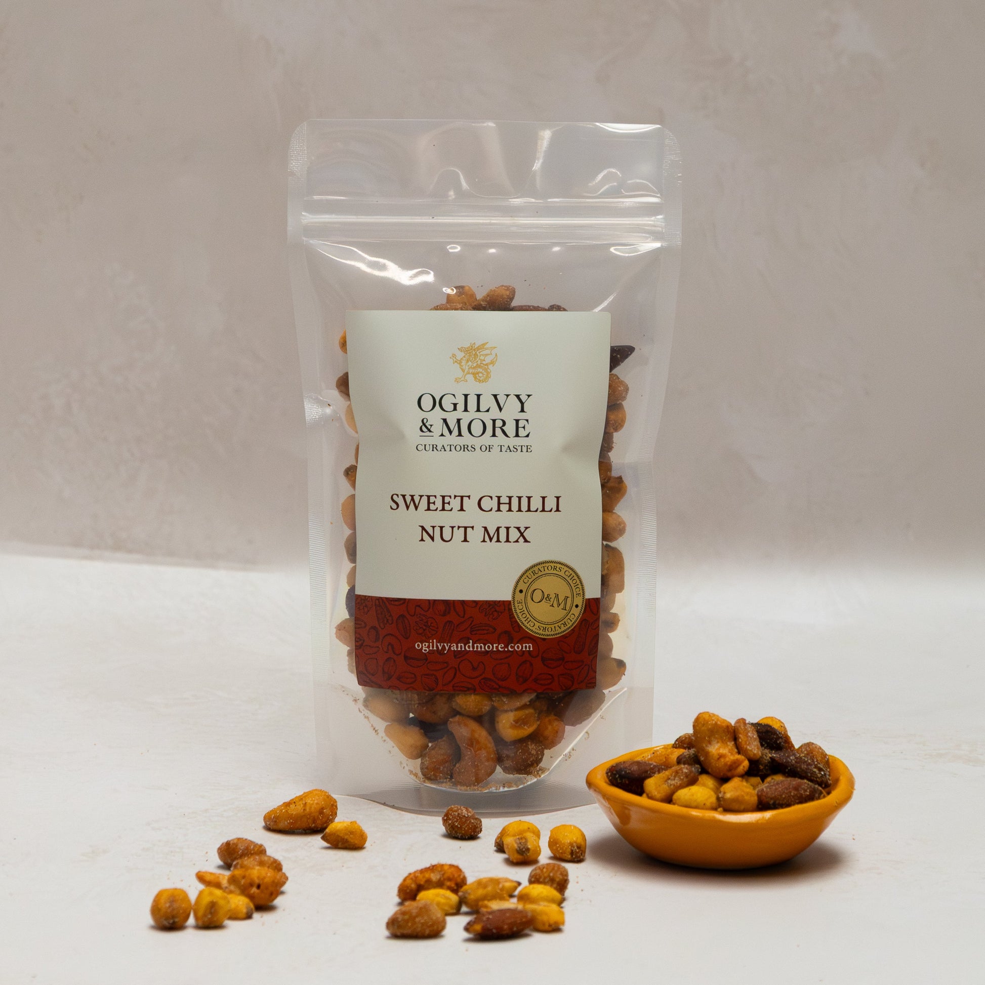 Ogilvy & More sweet chilli nut mix with a small bowl of nuts on a white background