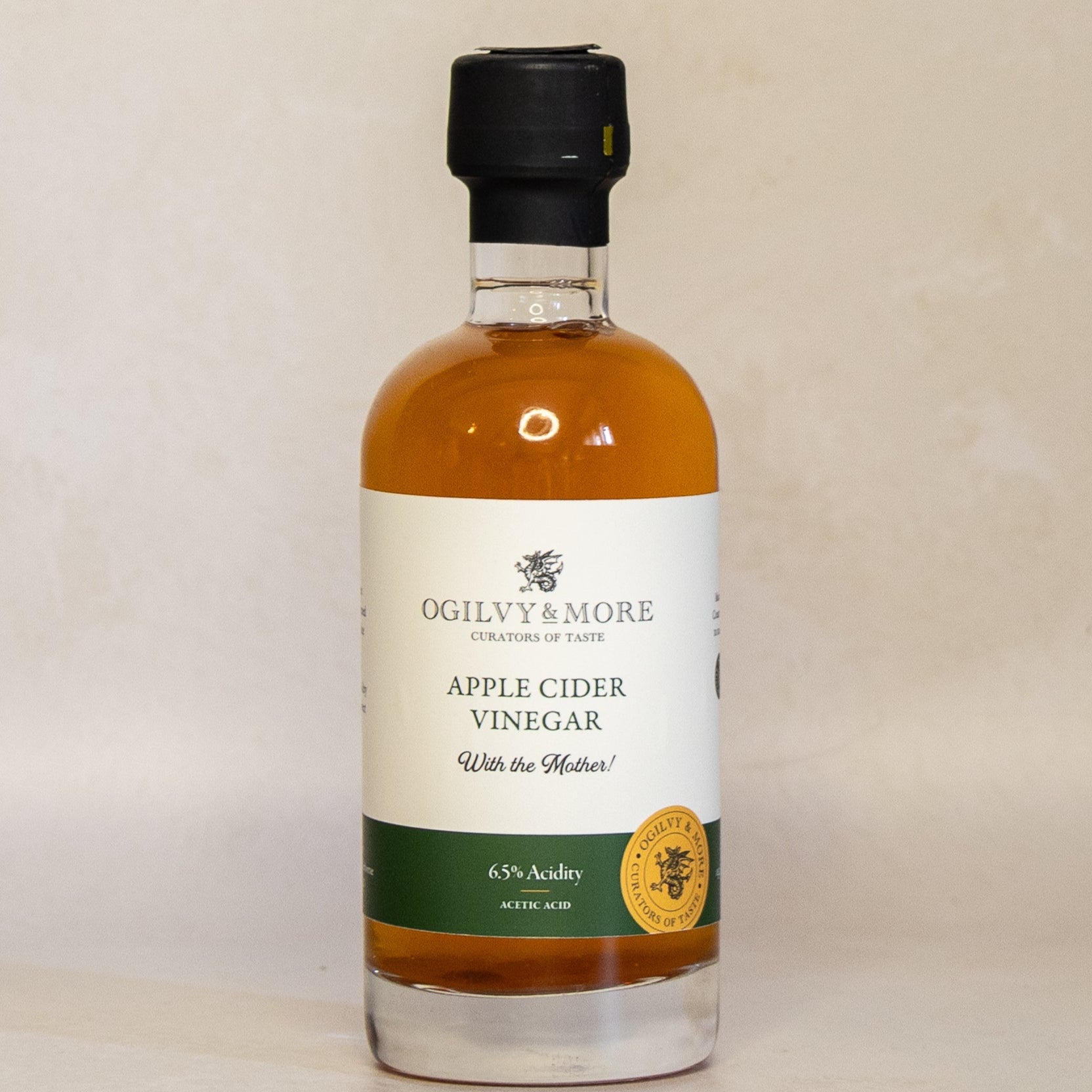 Bottle of Ogilvy & More Apple Cider Vinegar on a beige background