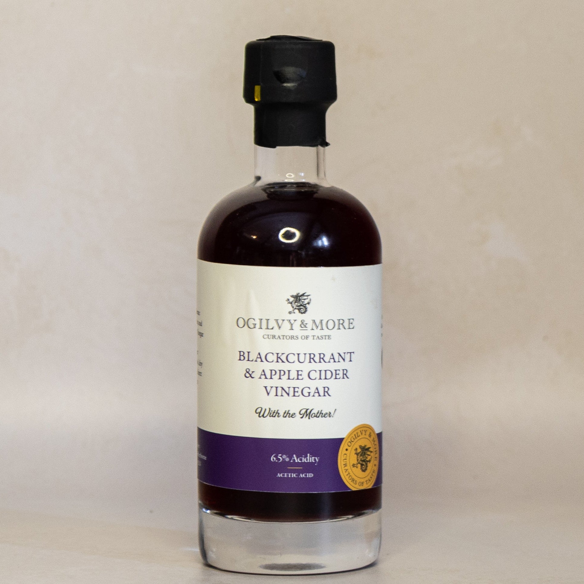 Bottle of Ogilvy & More Blackcurrant & Apple Cider Vinegar on a beige background