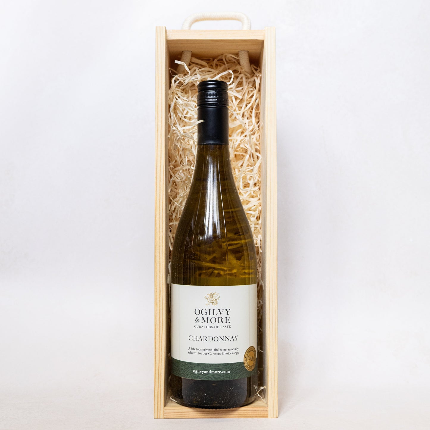 Ogilvy & More Chardonnay wine bottle in a wooden box on a white background