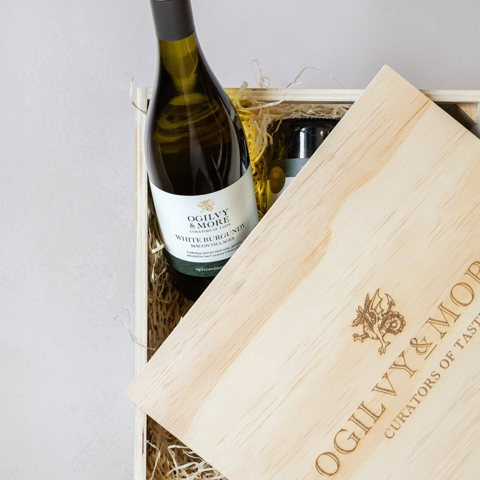 Bottle of Ogilvy & More Macon Villages in a wooden box with a white background