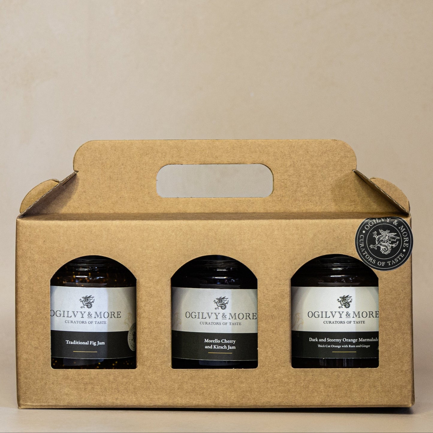 Three jars in a cardboard gift box with Ogilvy & More jam and chutney on a beige background