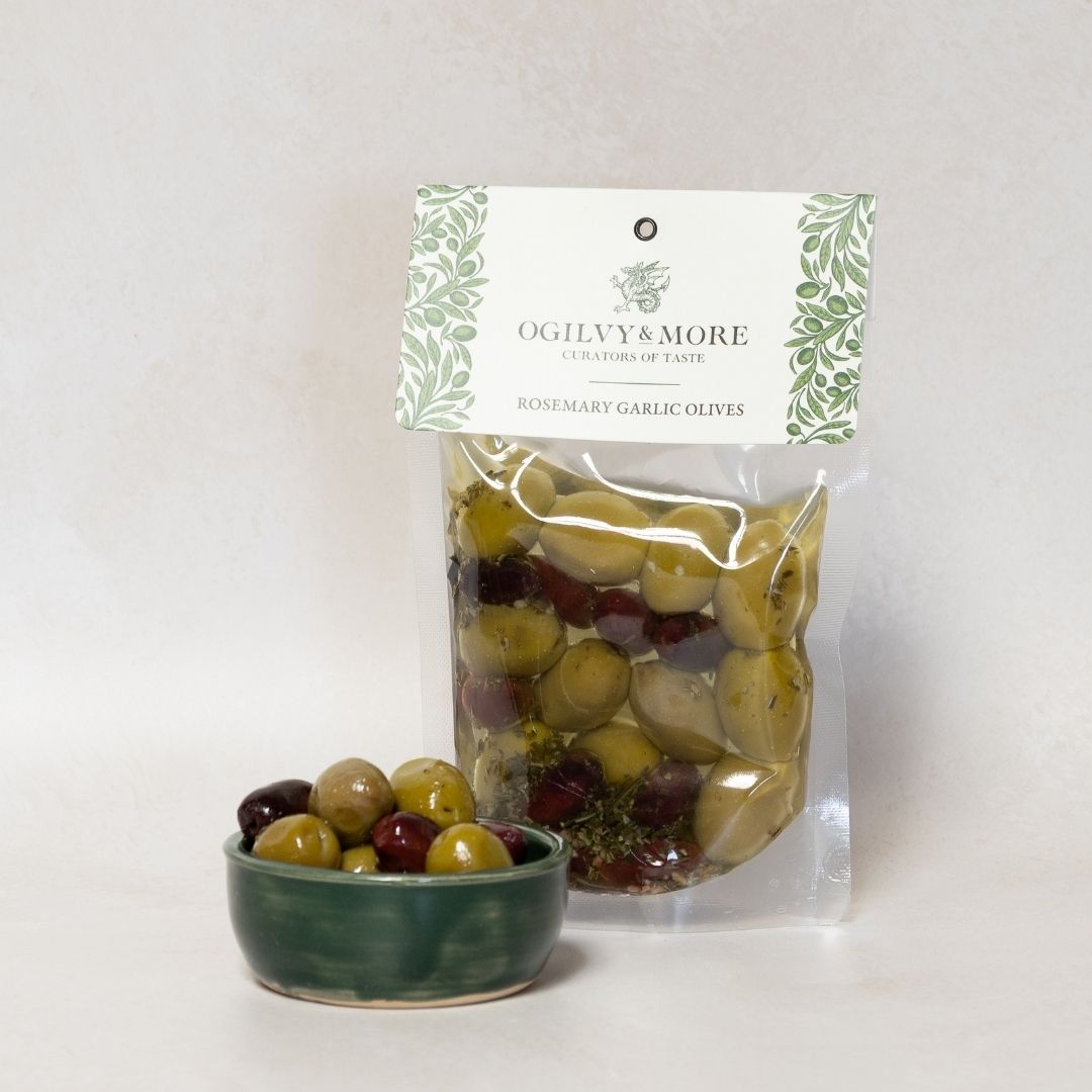 Ogilvy & More rosemary garlic olives with a small bowl of olives on a light gray background