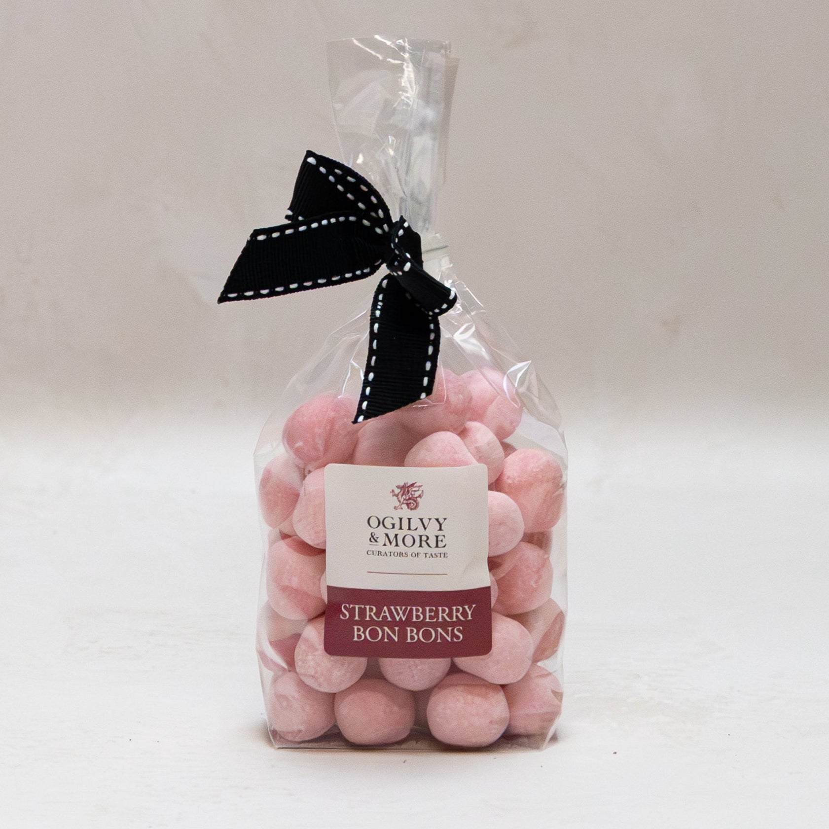 Bag of Ogilvy & More strawberry bonbons with a black bow on a white background