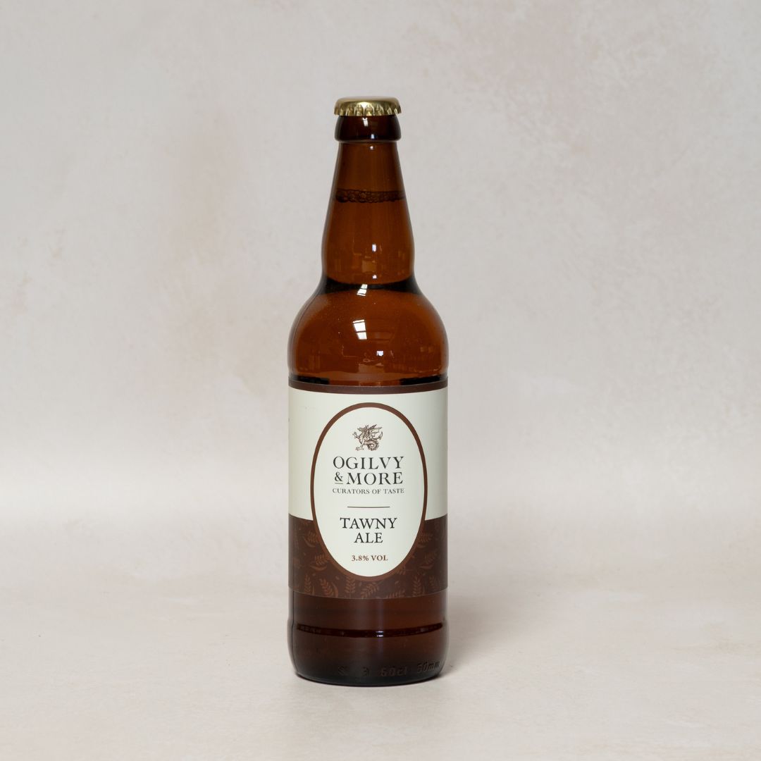 Brown bottle of Oglivy & More Tawny Ale on a light gray background