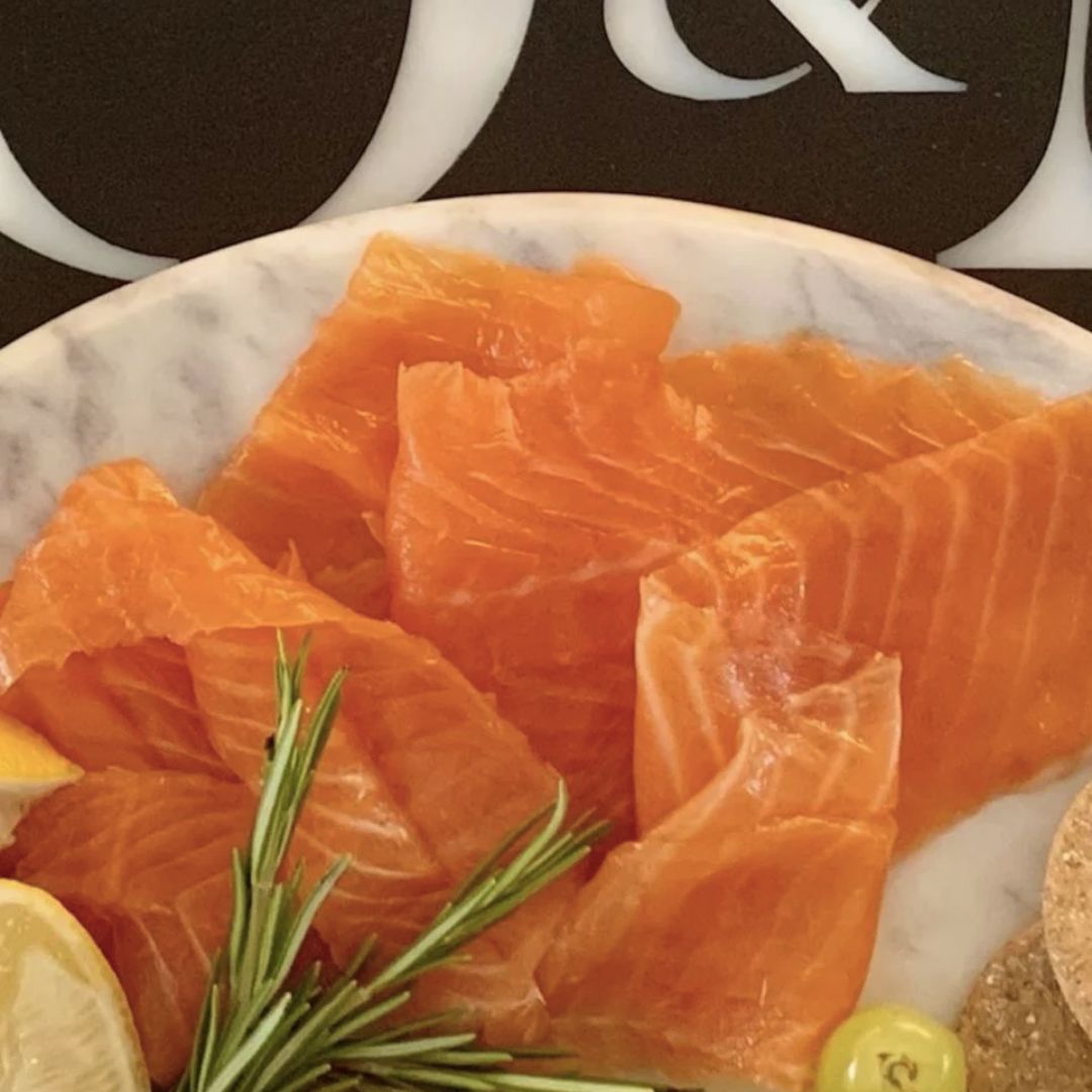 Smoked rainbow trout on a plate with rosemary and lemon,
