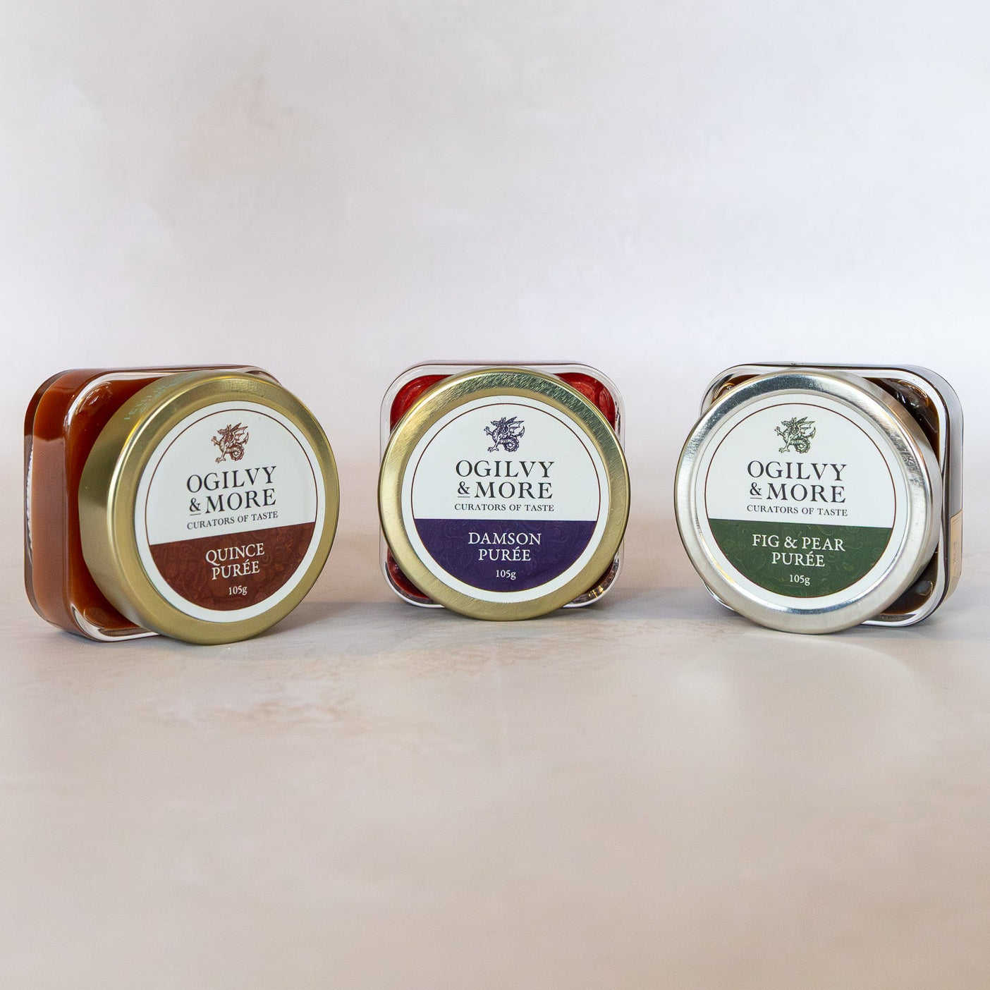 Three tins of Ogilvy & More puree on a light background