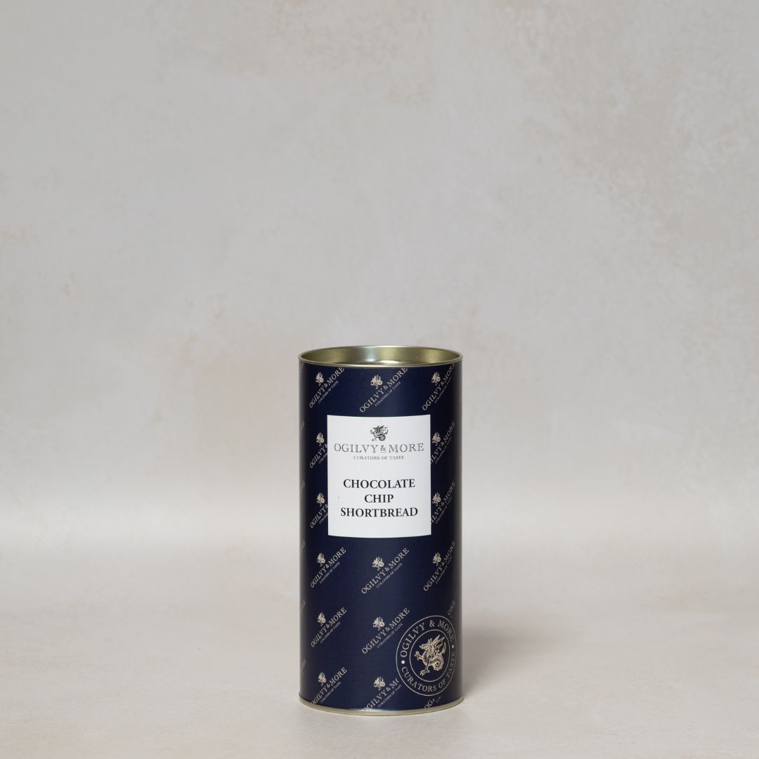 Blue cylindrical tin of Ogilvy & More chocolate chip shortbread with a white label on a light gray background