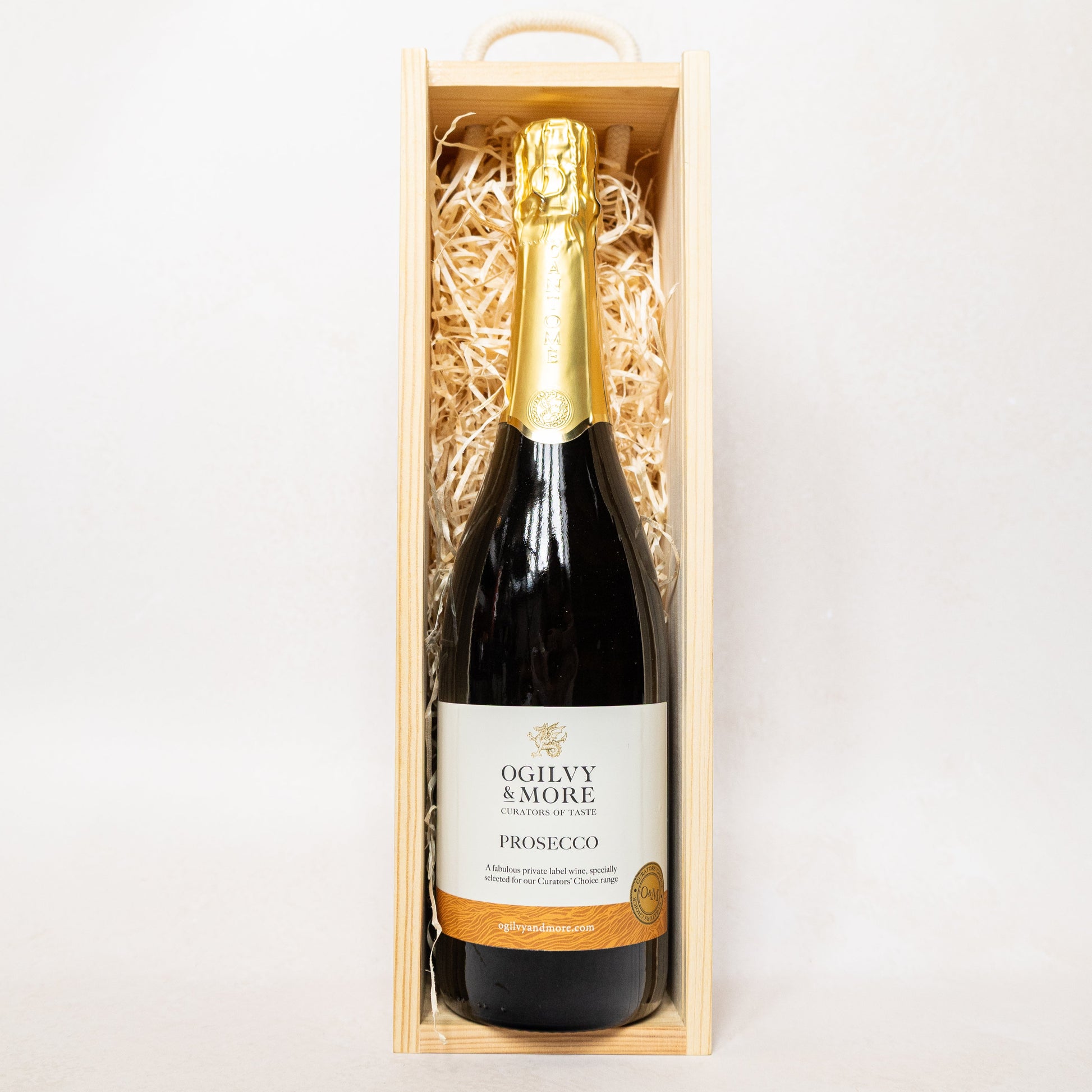 A bottle of Ogilvy & More Prosecco in a wooden gift box on a white background
