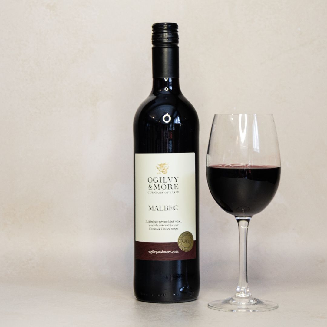 Bottle of Ogilvy & More Malbec wine with a glass of red wine