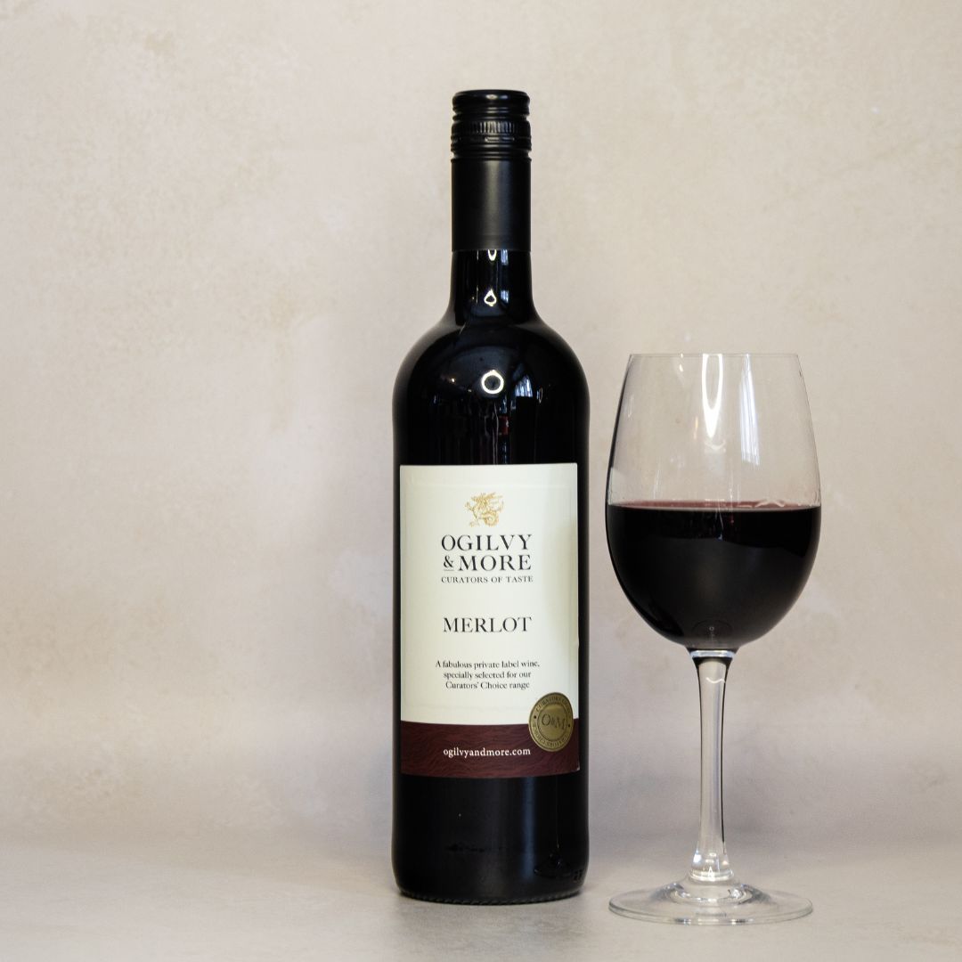 Bottle of Ogilvy & More Merlot wine with a glass of red wine