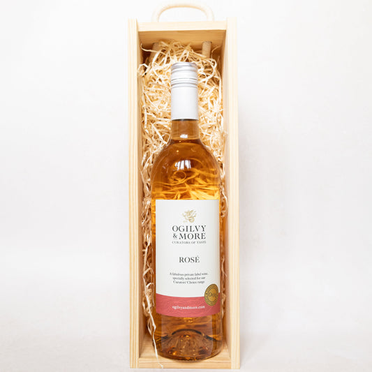 Bottle of Ogilvy & More Rose wine in a wooden box on a white background