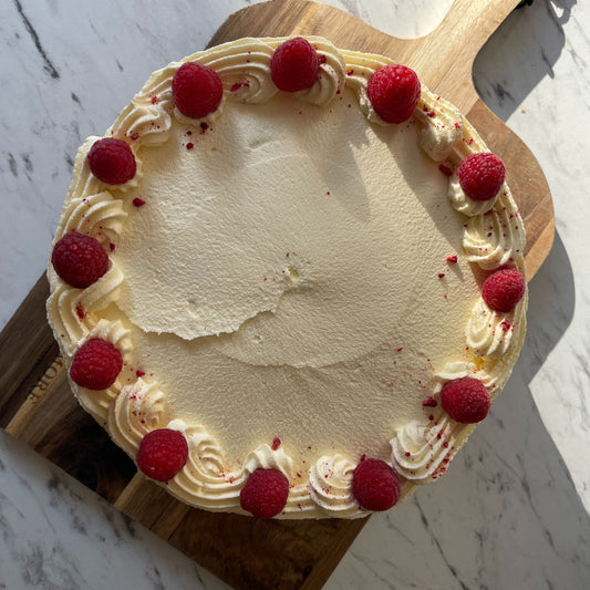 Cake with raspberries on a wooden board