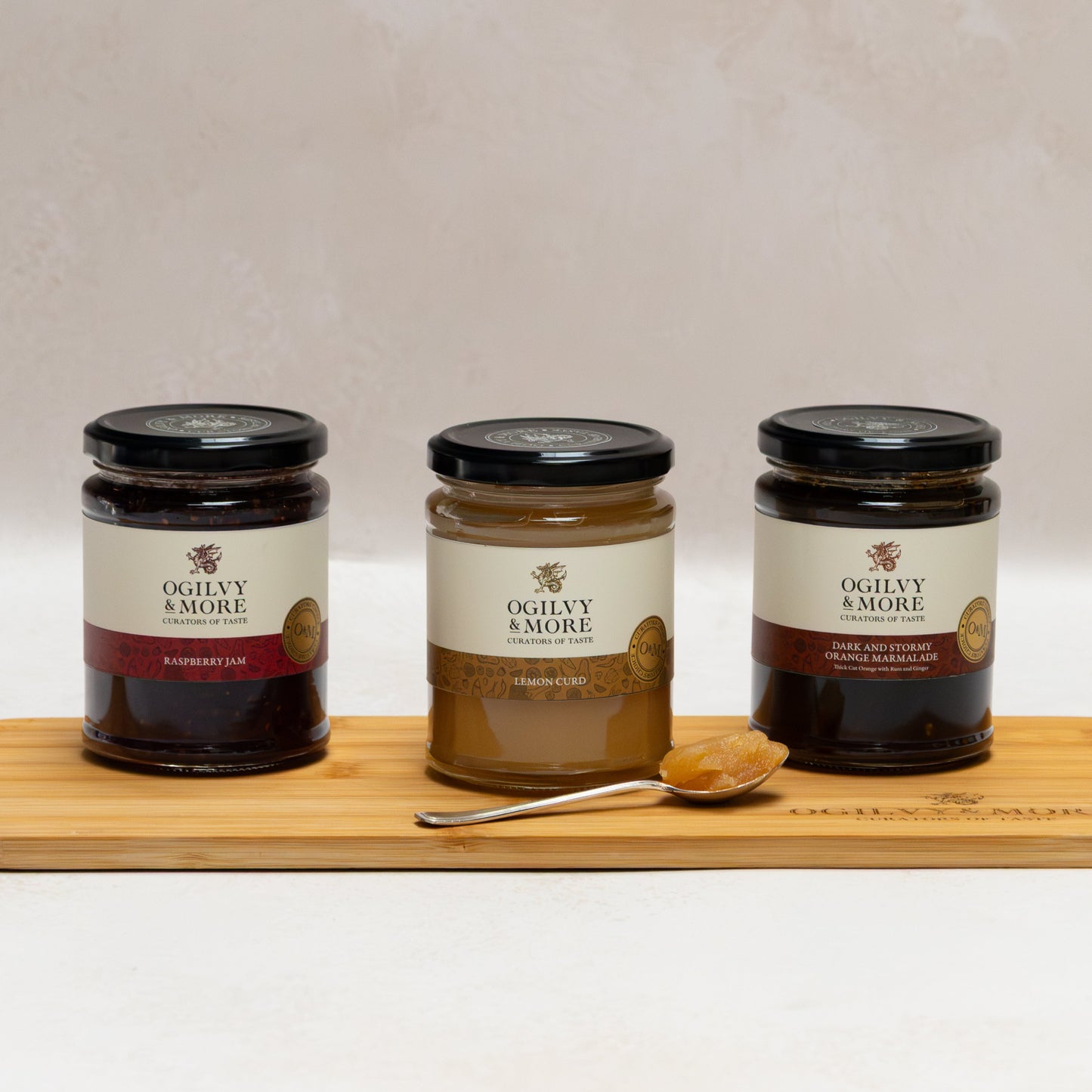 Three jars of Ogilvy &More Jam on a wooden board with a white background