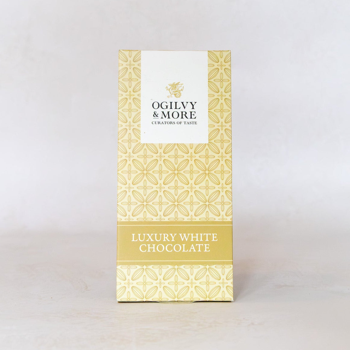 Luxury white chocolate bar packaging with 'Ogilvy & More' branding on a light gray background