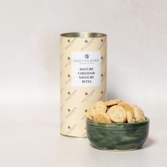 Bowl of Ogilvy & More Mature Cheddar savoury bites next to a cylindrical container on a light background