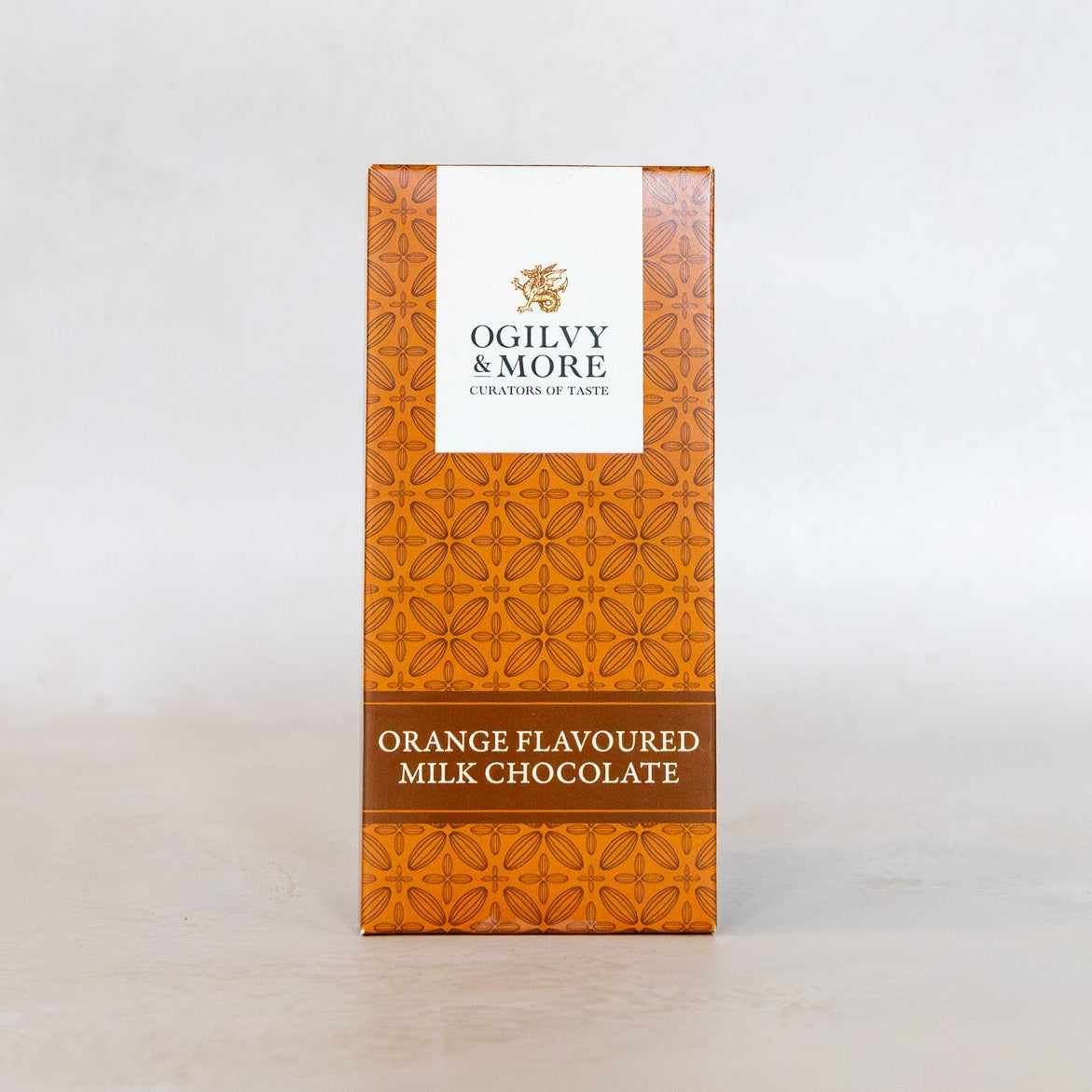 Orange-flavored milk chocolate packaging with Ogilvy & More logo on a white background