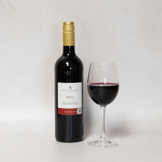 Ogilvy & More Rioja wine bottle and glass on a white background