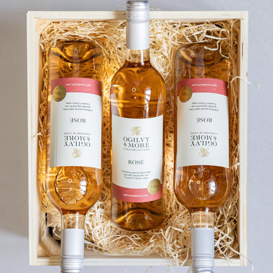 Three bottles of Ogilvy & More Rosé wine in a wooden gift box with straw liner.