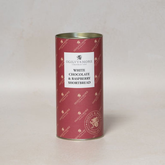 Red cylindrical Ogilvy & More White Chocolate and Raspberry Shortbread tin with white label on a light gray background