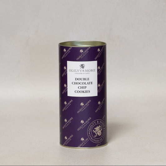 Purple cylindrical Ogilvy & More chocolate chip cookies tin with a white label on a light gray background