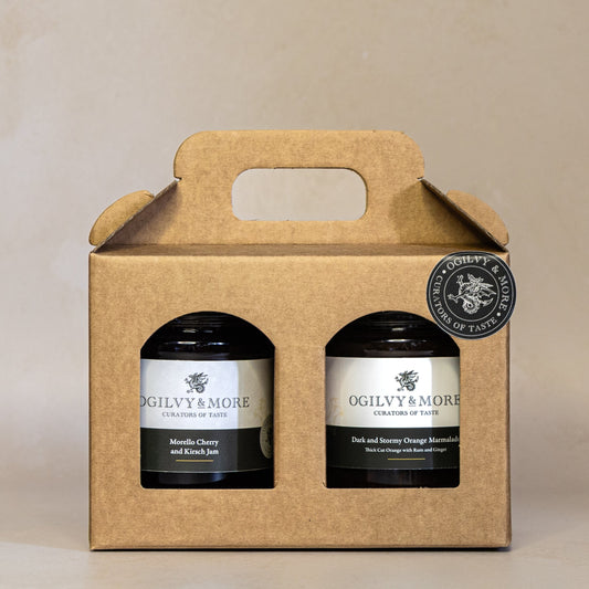 Two jars of Ogilvy & More jam and marmalade in a cardboard gift box on a beige background