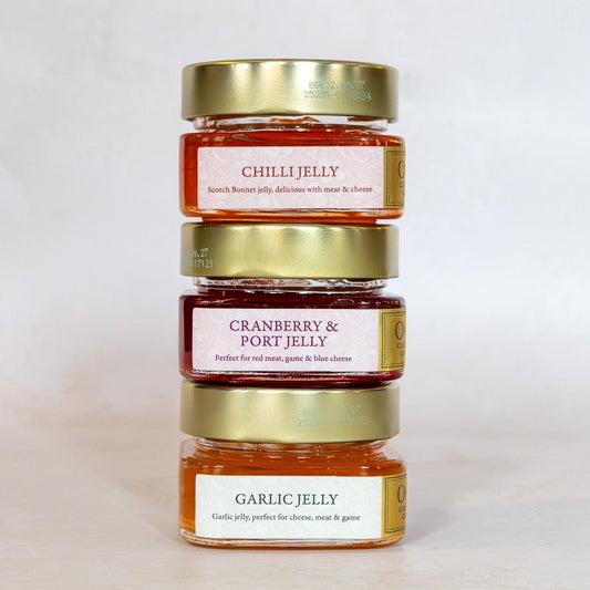 Three jars of Ogilvy & More jelly stacked on a light gray background