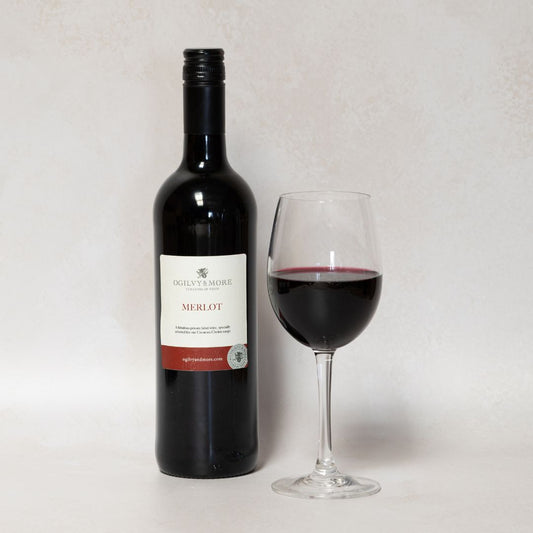 Bottle and glass of Ogilvy & More merlot on a light gray background