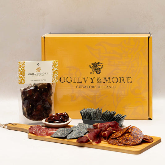 Ogilvy & More food gift set with charcuterie board and branded box on a beige background