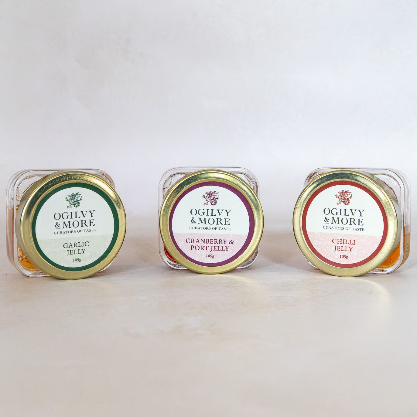 Three small containers of Ogilvy & More Jelly on a light background