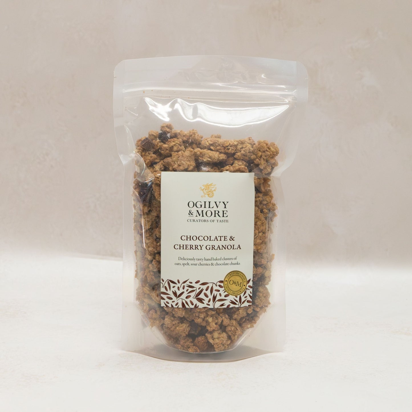 Packaged chocolate and cherry granola with Ogilvy & More label on a light background