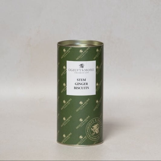 Green cylindrical tin of Ogilvy & More stem ginger biscuits on a light gray background